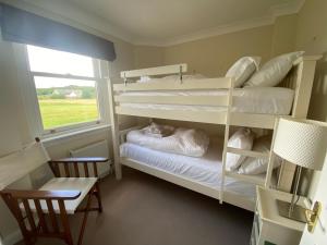 a bedroom with two bunk beds and a window at Golf Court View, Elie in Elie