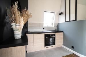 a small kitchen with a black counter and a window at Parisian cocoon under the roofs view Eiffel Tower in Paris