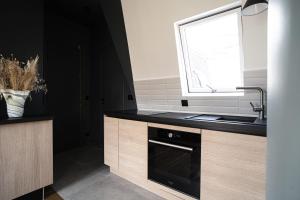 a kitchen with a sink and a window at Parisian cocoon under the roofs view Eiffel Tower in Paris