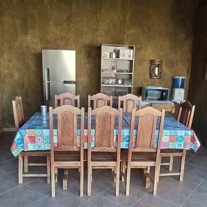 une cuisine avec une table avec des chaises et un réfrigérateur dans l'établissement Casa em Olímpia - Recanto Gonçalves, à Olímpia