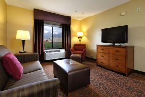 a hotel room with a couch and a flat screen tv at Hampton Inn & Suites Tucson Mall in Tucson