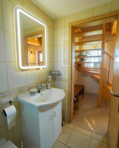 bagno con lavandino bianco e specchio di Villa VINEYARD a Velika Nedelja