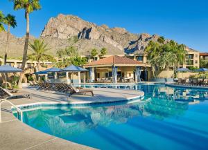 una piscina en un complejo con una montaña en el fondo en El Conquistador Tucson, A Hilton Resort en Tucson