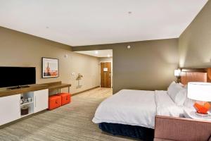 Habitación de hotel con cama y TV de pantalla plana. en Hampton Inn Suites Tucson Tech Park, en Tucson