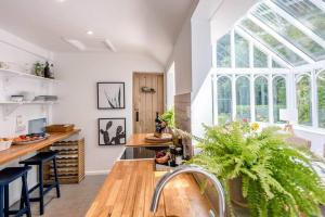 a kitchen with a table and a large window at Phoenix Cottage in Beccles