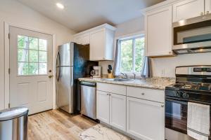 a kitchen with white cabinets and a stainless steel refrigerator at Cozy Glens Falls Getaway Less Than 1 Mi to Downtown in Glens Falls