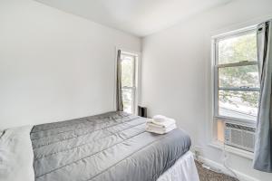 ein weißes Schlafzimmer mit einem Bett und zwei Fenstern in der Unterkunft Cozy Glens Falls Getaway Less Than 1 Mi to Downtown in Glens Falls