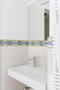 Baño blanco con lavabo y espejo en Residenza Amalphia, en Amalfi
