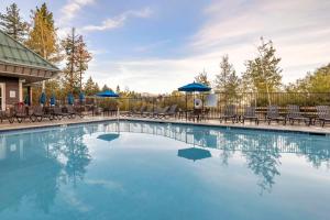 a swimming pool with chairs and blue umbrellas at Hilton Vacation Club Lake Tahoe Resort South in South Lake Tahoe
