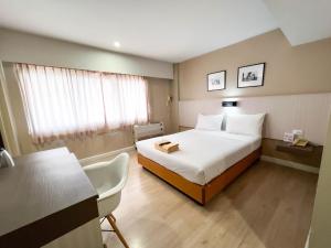 ein Hotelzimmer mit einem Bett und einem Tisch und Stühlen in der Unterkunft Srivichai Hotel in Nakhon Ratchasima