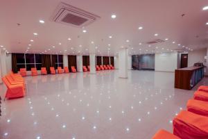 Duży pokój z pomarańczowymi krzesłami i białą podłogą w obiekcie Hotel Lalita Palace w mieście Dżajpur