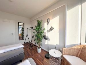- une chambre avec un lit et une plante dans l'établissement Zentrale Apartments im Herzen vom Bremerhaven, à Bremerhaven