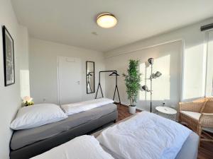 a bedroom with two beds and a plant in it at Zentrale Apartments im Herzen vom Bremerhaven in Bremerhaven