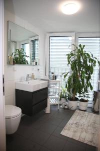 een badkamer met een wastafel, een toilet en een spiegel bij RoyalDeluxe Penthouse by Kevany in Keulen