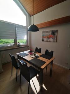 uma sala de jantar com uma mesa de madeira e cadeiras em Ferienwohnung Anneliese em Leutenbach