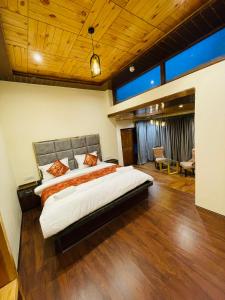 a large bedroom with a large bed and wooden floors at Thiksay Organic Resort in Ranbirpura
