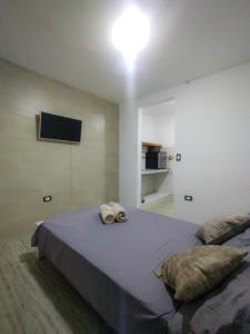 um quarto com uma cama com duas toalhas em Apartamento Sevilla, Valle del Cauca em Sevilla