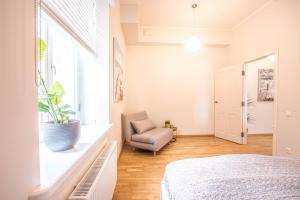 a bedroom with a bed and a chair and a window at Lossi 32 Cozy Apartment in Tartu