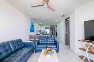 a living room with blue leather furniture and a flat screen tv at Casa Blanca Golf Villas in Puerto Peñasco