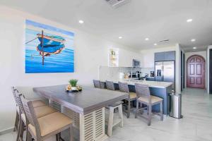 a kitchen with a table and chairs and a painting of a boat at Casa Blanca Golf Villas in Puerto Peñasco