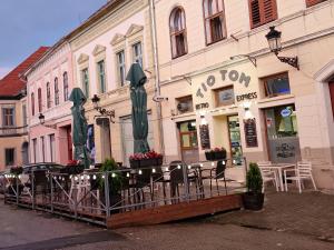 un restaurant avec des tables et des chaises en face d'un bâtiment dans l'établissement Fabini Apartments, à Mediaş