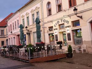 ein Restaurant mit Tischen und Stühlen vor einem Gebäude in der Unterkunft Fabini Apartments in Mediaş