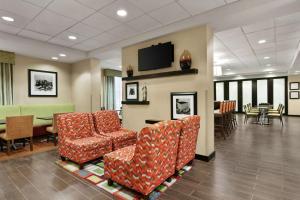 a waiting room with chairs and a flat screen tv at Hampton Inn Washington-Dulles International Airport South in Chantilly