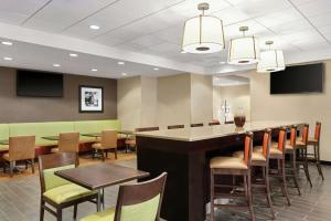 a restaurant with a bar with chairs and tables at Hampton Inn Washington-Dulles International Airport South in Chantilly +23 photos