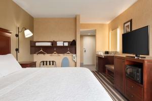 a hotel room with a bed and a flat screen tv at Hampton Inn Washington-Dulles International Airport South in Chantilly