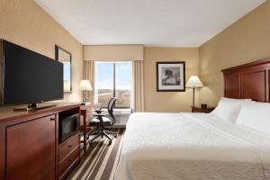 a hotel room with a bed and a flat screen tv at Hampton Inn Washington-Dulles International Airport South in Chantilly