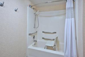 a bathroom with a shower with a white shower curtain at Hampton Inn Washington-Dulles International Airport South in Chantilly