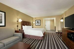 a hotel room with a bed and a couch and a television at Hampton Inn Washington-Dulles International Airport South in Chantilly