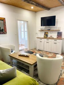 a living room with a table and a tv at Maul - Lator Présbár és Bortrezor in Villány +10 photos