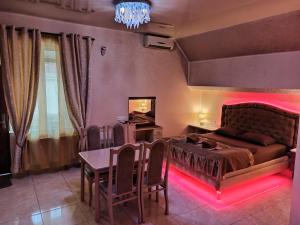 a bedroom with a bed and a table with red lights at ApartHotel Dom in Odesa