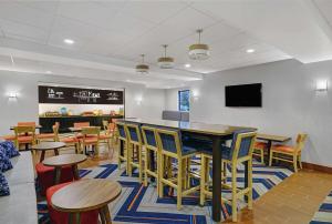 a restaurant with tables and chairs and a bar at Hampton Inn Utica in Utica