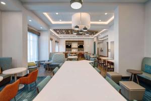 Hampton Inn & Suites By Hilton Waterloo St. Jacobs في واترلو: قاعة اجتماعات كبيرة مع طاولة وكراسي كبيرة
