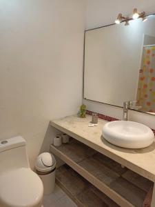 ein Badezimmer mit einem Waschbecken, einem WC und einem Spiegel in der Unterkunft TR3S by Walter de la Renta in Cancún