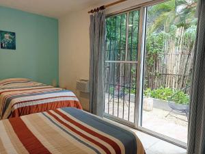 1 Schlafzimmer mit 2 Betten und einer Glasschiebetür in der Unterkunft TR3S by Walter de la Renta in Cancún