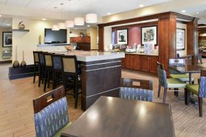 a restaurant with a bar and tables and chairs at Hampton Inn Waynesboro/Stuarts Draft in Fishersville