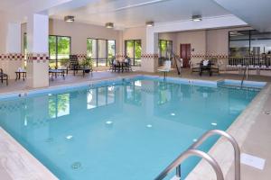 a large pool in a hotel with tables and chairs at Hampton Inn Waynesboro/Stuarts Draft in Fishersville