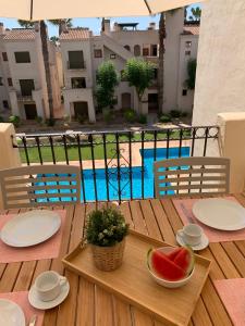 a wooden table with a bowl of watermelon on it at Roda Golf Sunparadise in San Javier