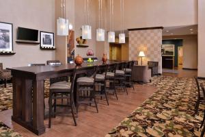 un gran bar en una habitación de hotel con taburetes en Hampton Inn & Suites Woodward, en Woodward