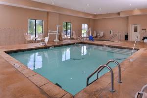 a swimming pool in a hotel with chairs and tables at Hampton Inn & Suites Woodward in Woodward