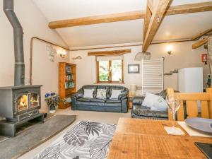 a living room with a wood stove and a couch at Egg Pudding Stone in Grange Over Sands