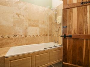 a bathroom with a bath tub and a shower at Egg Pudding Stone in Grange Over Sands +24 photos