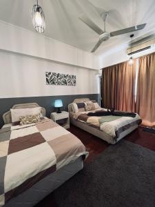 1 dormitorio con 2 camas y ventilador de techo en The Roomah en Bentong
