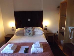 um quarto com uma cama com duas toalhas em The Inn on the Loch em Castle Douglas