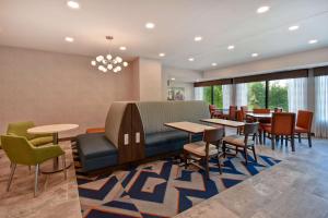 a waiting room with tables and chairs and a couch at Hampton Inn Potomac Mills Woodbridge in Woodbridge