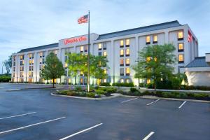 un hotel con bandera americana en un estacionamiento en Hampton Inn Woodbridge, en Woodbridge