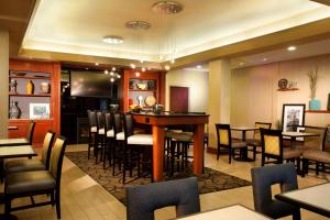 a restaurant with a bar with chairs and tables at Hampton Inn Woodbridge in Woodbridge
